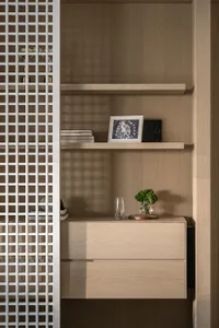 A modern wooden storage system with shelves and drawers, featuring a sleek design with white grid paneling.
