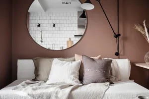 A minimalist bedroom featuring linen bedding and subtle brown walls
