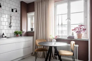 Modern, minimalist kitchen with white subway tiles and dark wooden furniture.