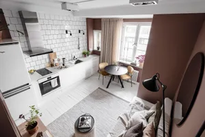 Modern minimalist living and dining room with neutral tones and functional design.