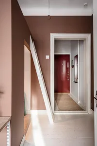 A minimalist entryway featuring wood flooring and painted walls.