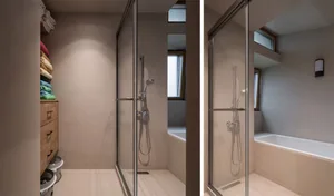 A minimalist bathroom with a glass-enclosed shower and a modern bathtub, showcasing sleek lines and a neutral color palette.