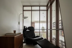 A minimalist living room with industrial design elements, featuring metal furniture and a floor lamp.