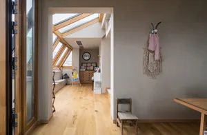 An industrial living space featuring wooden flooring and exposed beams.