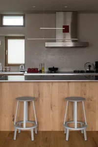 Industrial-style residential kitchen with wooden cabinets and stainless steel appliances.