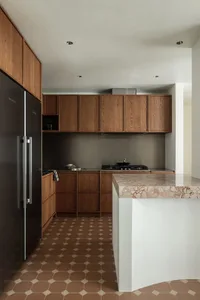 Modern minimalist kitchen with wooden cabinets, marble countertops, and wooden tiles on the floor.