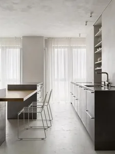 A modern, minimalist kitchen with concrete finishes and a sleek, open layout.