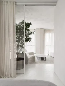 A minimalist living room featuring clean lines and a concrete floor.