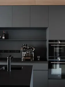 Modern, minimalist residential kitchen featuring a sleek metal countertop.