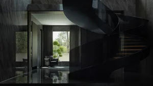 A modern black staircase with glass railings and marble flooring.