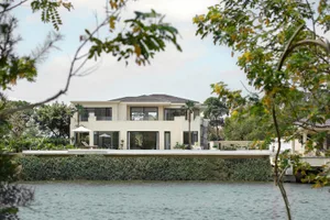 Modern house exterior with glass frame and tile roof.