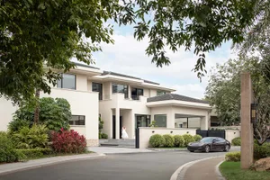Modern residential exterior featuring contemporary design elements with concrete and glass materials.