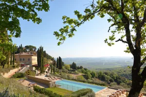 Resort villa with a pool overlooking a scenic landscape with stone and glass elements.