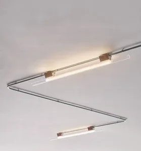 An industrial-style ceiling light fixture with metal and glass components.