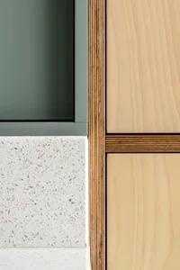 Modern minimalist kitchen featuring wood panels and terrazzo countertop.