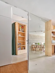 A modern office space featuring wooden shelves and concrete walls.