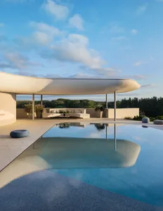 A minimalist pool area featuring concrete and glass materials.