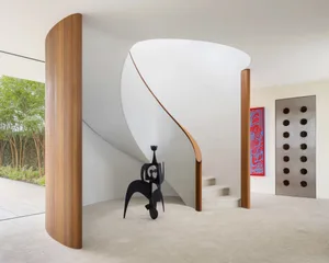 Modern concrete staircase with wooden accents and abstract artwork.