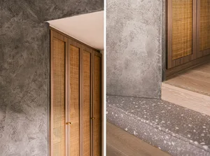 A minimalist staircase with concrete and wovenfiber panels, featuring a terrazzo step.