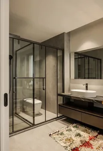 Modern bathroom featuring glass shower enclosure, marble countertop, and concrete floor.