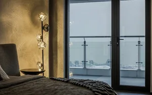 A modern residential bedroom featuring textured wallpaper on the wall.
