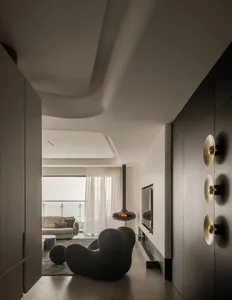 Minimalist modern living room featuring a concrete fireplace and comfortable seating.