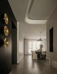 Modern minimalist living room with concrete floor and glass walls, showcasing clean lines and natural light.
