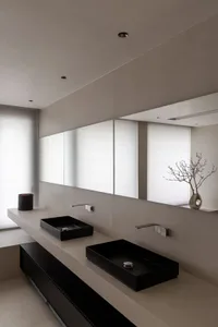 Modern minimalist bathroom with glass sinks and large mirror.