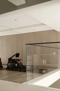 A minimalist gym room featuring wooden panels and a rowing machine.