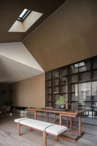 Minimalist living room featuring wooden furniture and glass elements.