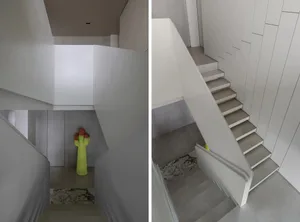 Modern minimalist staircase with white concrete steps, wooden railings, and a cactus sculpture.