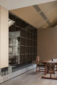 Modern dining room featuring wooden walls and a glass-enclosed area.