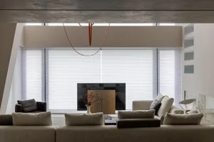 Modern interior design featuring a living room with fabric cushions and concrete veneer walls.
