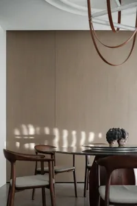 簡約風格的餐廳，擺放圓形木質餐桌與餐椅，窗外自然光線灑落室內。