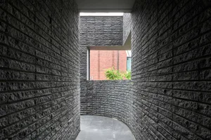A minimalist interior space with concrete walls and a window.
