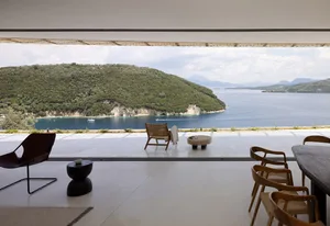 Modern minimalist living room with concrete floor, minimalist design, and ocean view.