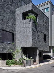 A modern building with a black concrete facade featuring clean lines and minimalist design.