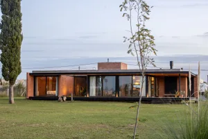 A modern house with brick and large glass windows.
