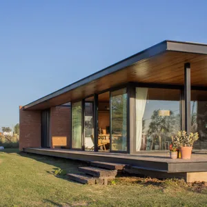Modern residential house with large glass windows and brick walls.