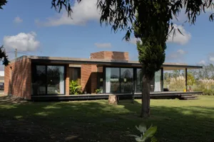 A modern house with brick exterior and large glass windows.