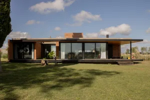 A modern residential exterior featuring brick, concrete, and glass materials.