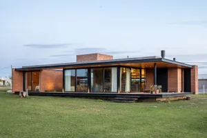 A modern residential exterior featuring brick and glass materials.