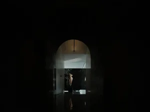 極簡大廳，深色大理石牆前擺放一座雕塑。