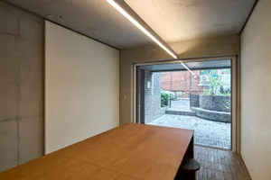 Minimalist office space with concrete walls and table.