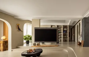 A modern living room with a concrete floor, minimalist decor, and a large television screen.