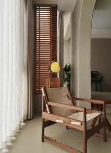 Contemporary room featuring wooden furniture, leather accents, Venetian blinds, and white curtains.