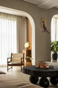 A modern living room with a wooden coffee table and a beige armchair.