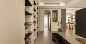 Minimalist residential interior featuring a concrete floor and white bookshelf with decorative items.
