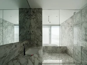 A minimalist bathroom featuring marble walls and flooring.