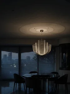 A minimalist interior design featuring a metallic chandelier hanging from the ceiling.